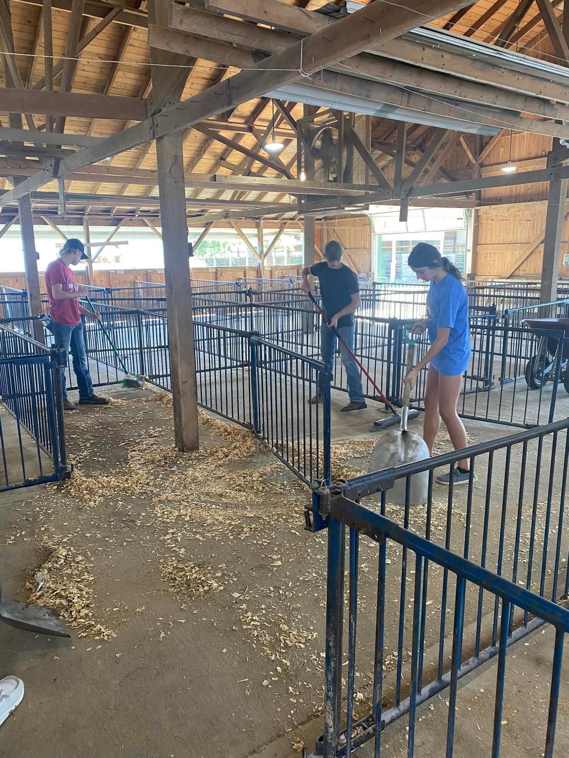 Highlander 4-H members Jacob Hartzler, Erika Thomann, and Brock Thomann helped the club raise money by cleaning goat pens after the Iowa Meat Goat Association show at the fairgrounds.